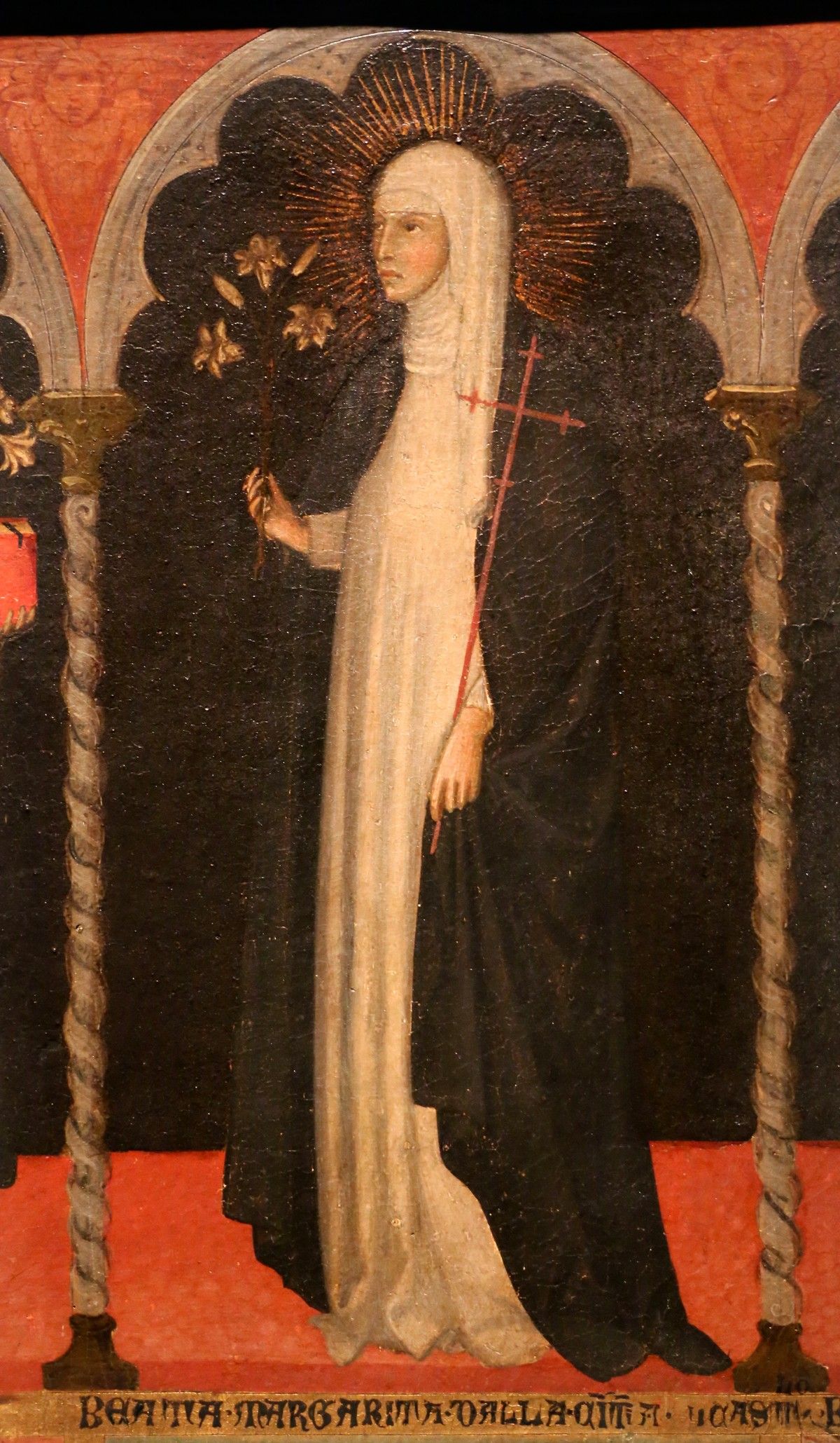 Margaret of Castello in a black-and-white Dominican habit, standing beneath a red Gothic arch, from a fourteenth-century altarpiece.